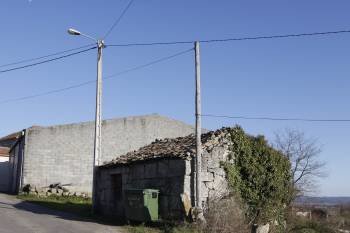 Una de las casas deshabitadas de Boado con una farola al lado, que ilumina la calle. (Foto: XESÚS FARIÑAS)