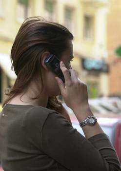 Una mujer atiende una llamada a su teléfono móvil en la calle.