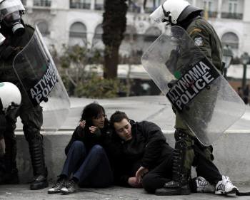 Policías antidisturbios custodian a dos manifestantes durante los enfrentamientos en Atenas, Grecia (Foto: EFE)