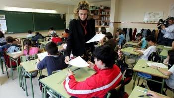 Una profesora reparte exámenes en una clase de niños de primaria. (Foto: ARCHIVO)
