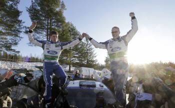 El piloto finlandés Jari-Matti Latvala (d) y su copiloto Miika Anttila (i) celebran junto a su Ford Fiesta RS WRC su victoria en el Rally de Suecia (Foto: EFE)