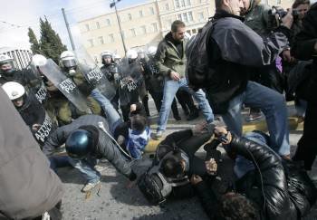 Policias cargan contra manifestantes y fotógrafos durante el desarrollo de una protesta frente al parlamento griego en Atenas (Foto: EFE)