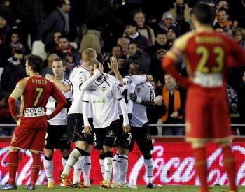 Los jugadores del Valencia celebran su segundo gol frente el Sporting de Gijón, conseguido en propia puerta por el defensa Alberto Botía (Foto: EFE)