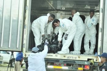 Forenses suben en un camión algunos de los restos de las  víctimas mortales del incendio registrado en la Granja Penal de Comayagua. EFE