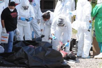 Médicos forenses examinan el cuerpo de uno de los presos fallecidos. (Foto: GUSTAVO AMADOR)