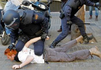 Un policía custodia a un detenido (i) durante los incidentes entre estudiantes y policías registrados hoy en el centro de Valencia.  (Foto: EFE)