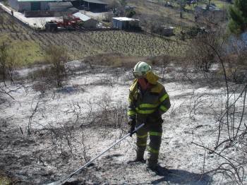 Un brigadista, en medio de los restos del incendio producido en las proximidades de O Barco. (Foto: J.C.)