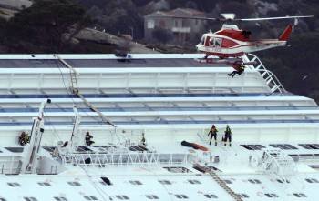 Un helicóptero de rescate sobrevuela el casco del crucero 'Costa Concordia', escorado junto a la isla de Giglio (Foto: EFE)