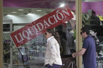 Un establecimiento comercial cuelga el cartel que anuncia la liquidación de sus articulos. (Foto: ARCHIVO)