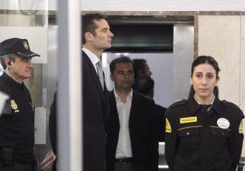 Iñaki Urdangarín, a la entrada del Juzgado de Palma, franqueado por un policía y una vigilante jurado. (Foto: BALLESTEROS)