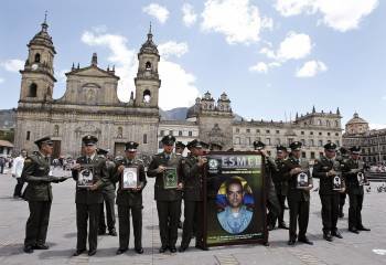 Policías colombianios muestran las fotografías de sus compañeros secuestrados por las FARC. (Foto: LEONARDO MÚÑOZ<)