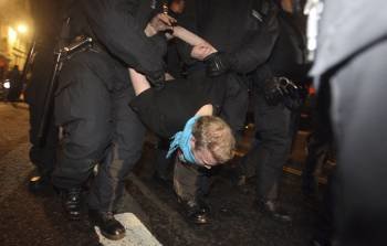 Un grupo de agentes detiene a un manifestante durante el desalojo de los indignados de Londres. (Foto: LEWIS WHYLD)