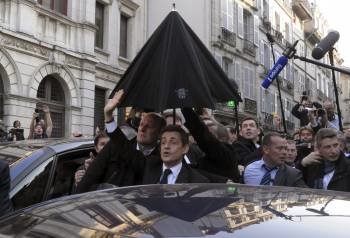Nicolas Sarkozy es arropado por sus escoltas en Bayona. (Foto: GUILLAUME)