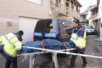 Dos operarios de un funeraria introducen los dos cadáveres en el furgón judicial para realizarle la autopsia en el Hospital Comarcal de Verín (Foto: XESÚS FARIÑAS)
