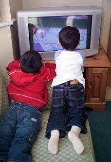 Dos niños viendo la televisión.