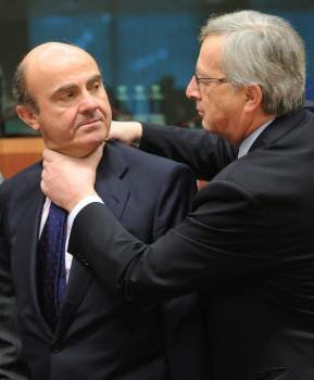 El presidente del Eurogrupo Jean-Claude Juncker bromea con el ministro español de Economía, Luís de Guindos al comienzo de la reunión del Eurogrupo en Bruselas. Foto: Olivier Hoslet