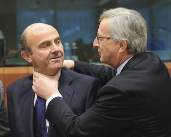 El presidente del Eurogrupo Jean-Claude Juncker (d) bromea con el ministro español de Economía, Luís de Guindos (i) al comienzo de la reunión del Eurogrupo en Bruselas.