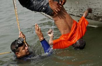Un submarinista que colabora en las labores de rescate recupera cadáveres del río Meghna, a su paso por el distrito de Munshiganj (Bangladesh).