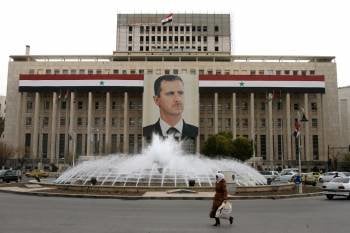 Una imagen de Al Assad preside la fachada del banco central de Damasco. (Foto: ARCHIVO)