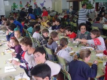 Numerosos niños, durante la hora de la comida en un comedor escolar.