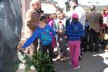 Un niño coloca flores sobre el monolito de Ruíz Padrón. (Foto: LUIS BLANCO)