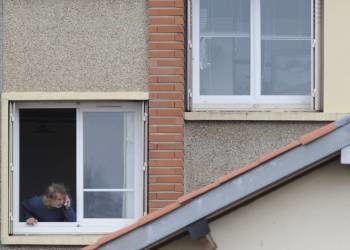 Un vecino observa desde la ventana la operación policial que tiene lugar en el barrio Coté Pavé de la ciudad del Tour de Francia para detener a un sospechoso de haber cometido siete asesinatos en la zona, tres de ellos niños (Foto: efe)