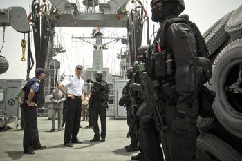 El príncipe Felipe recibe hoy, 21 de marzo de 2012, explicaciones de uno de los miembros de la Unidad de Guerra Naval Especial (UGNE), a bordo del buque de aprovisionamiento de combate 'Patiño' desplegado en la misión 'Atalanta' de la UE de lucha contra l