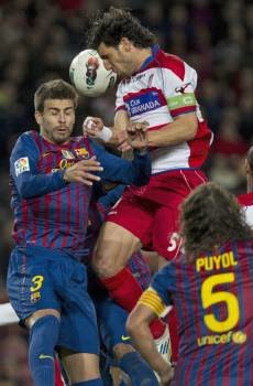 El defensa del F. C. Barcelona, Gerard Piqué (i), pelea un balón con el jugador del Granada, Diego Mainz (Foto: EFE)