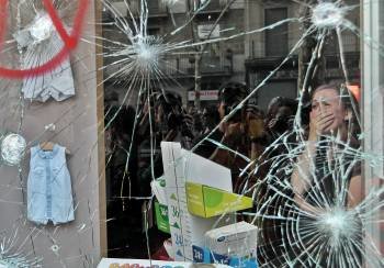 Una mujer llora tras ser apedreada la cristalera de su comercio en Barcelona (Foto: ALBERTO ESTÉVEZ)