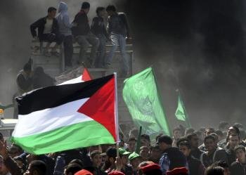 Manifestantes palestinos ondean banderas nacionales y de Hamas durante una protesta con motivo del Día de la Tierra.