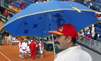 Los tenistas austríacos esperan a que amaine la lluvia durante el partido de dobles de la segunda jornada de la Copa Davis que disputan contra los españoles Marcel Granollers y Marc López (Foto: EFE)