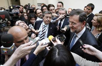 Mariano Rajoy rodeado de periodistas cuando intentaba salir del edificio del Senado. (Foto: PACO CAMPOS)