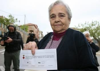 Una vecina de Rasquera muestra la papeleta para participar en la consulta convocada por el Ayuntamiento. (Foto: J.S.)