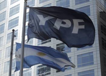 Las banderas de YPF y Argentina ante la sede de la petrolera en Buenos Aires. (Foto: LEO DEL VALLE)
