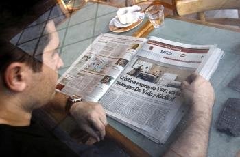 Un hombre desayuna mientras se informa sobre la expropiación de YPF anunciada ayer por el Gobierno argentino (Foto: EFE)
