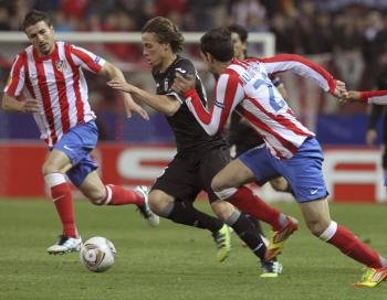  El delantero del Valencia CF, Sergio Canales (c), controla el balón entre Gabi Fernández  y Juanfran, del Atlético de Madrid (Foto: EFE)