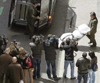 Empleados de la funeraria introducen el cadáver en el furgón. (Foto: PACO CAMPOS)