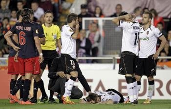 Los jugadores del Valencia CF reaccionan ante la lesión de su compañero Canales (en el suelo) durante el partido de vuelta de semifinales de la Liga Europa (Foto: EFE)