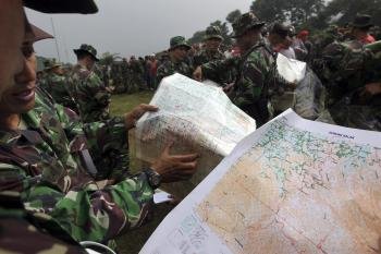 Un equipo de rescate indonesio mira un mapa mientras escalan la montaña Salak para encontrar el lugar del accidente del avión ruso Sukhoi Superjet 100 en Bogor, Indonesia (Foto: EFE)