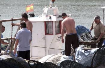 Pescadores en las labores de preparación de las redes ayer, en el puerto de la Atunara. (Foto: J. RAGEL.)