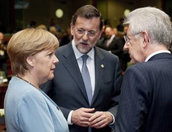 Mariano Rajoy conversa con Ángela Merkel y Mario Monti momentos antes de la cumbre. (Foto: HORST WAGNER)