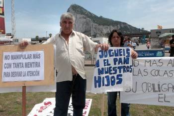 Dos trabajadores españoles en Gibraltar sujetan pancartas durante la concentración. (Foto: A. CARRASCO)