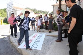La alcaldesa, Pilar López, esquiva la pancarta colocada por vecinos de Fraguas, Vilaboa, Vilaflor y A Silva. (Foto: XESÚS FARIÑAS)