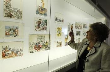 Una mujer observa algunos de los dibujos que forman la exposición '(Breve) Historia de la gente'. Foto: EFE Ángel Díaz