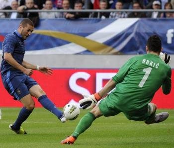 El jugador de la selección francesa Karim Benzema (c) patea el balón ante el guardameta de Serbia Zeljko Brkic durante el juego amistoso en el estadio Auguste Delaune de Reims (Francia). Foto EFE/YOAN VALAT
