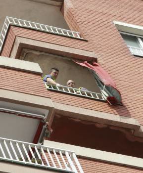 Los Mossos inspeccionan el balcón desde donde cayó la víctima. (Foto: T. GARRIGA)