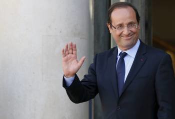 El presidente francés, Francois Hollande, saluda a la prensa a su llegada ayer al Eliseo. (Foto: IAN LANGSDON)