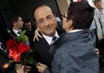 El presidente francés, François Hollande, recibe el beso de una simpatizante tras votar en Tulle. (Foto: G. HORCAJUELO)