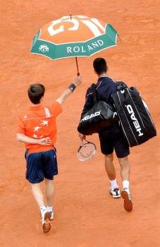 El tenista serbio Novak Djokovic abandona la pista mientras la lluvia interrumpe la final de Roland Garros