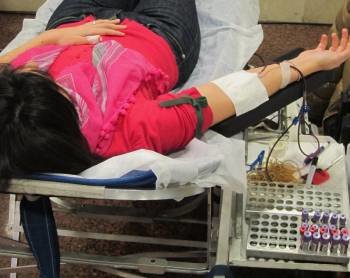 Una mujer tumbada en la camilla mientras realiza la donación de sangre. (Foto: EP)